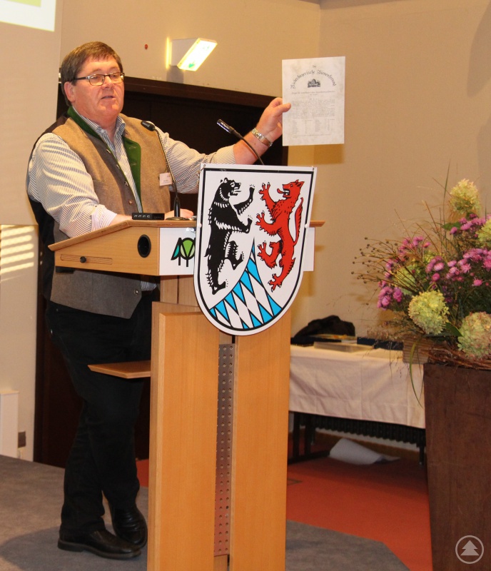 Otto Kötterl, Vorsitzender des Bezirksverbandes der Imker Niederbayern, präsentiert das historische Infoblatt der Imker aus dem Jahr 1895.