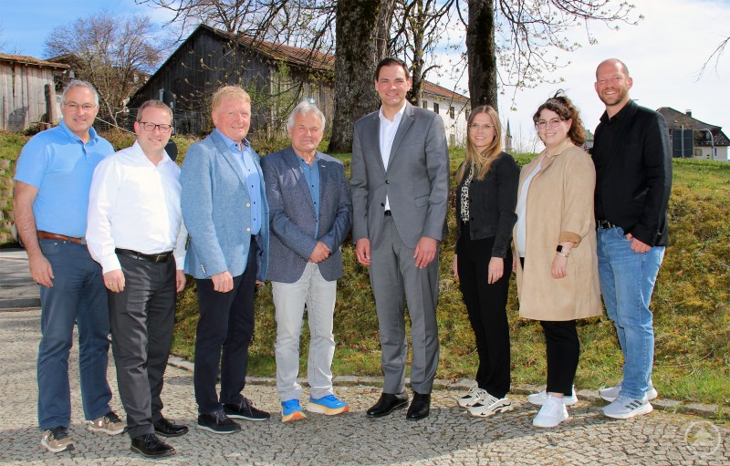 Landrat Sebastian Gruber (5. v.l.) mit Vertretern des BLSV Niederbayern und Mitarbeitenden des Landratsamts Freyung-Grafenau beim Austausch zur Sportförderung. Gruppenfoto von acht Personen im Freien vor ländlicher Kulisse – Vertreter des BLSV und des Landratsamts Freyung-Grafenau beim Treffen zur Sportentwicklung.
