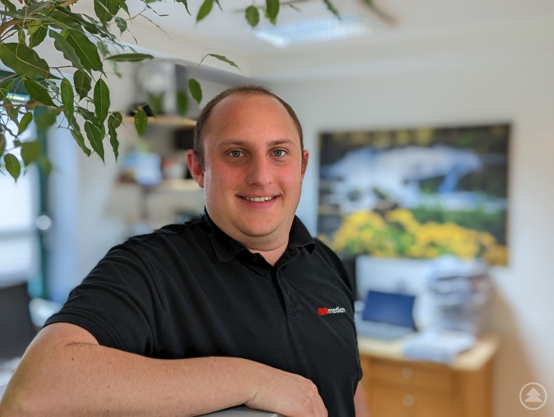 Andreas Bildl, CTO der BWmedien GmbH, berät Unternehmen zur rechtssicheren E-Mail-Archivierung. Ein Mann im Büro erklärt eine E-Mail-Archivierungslösung.