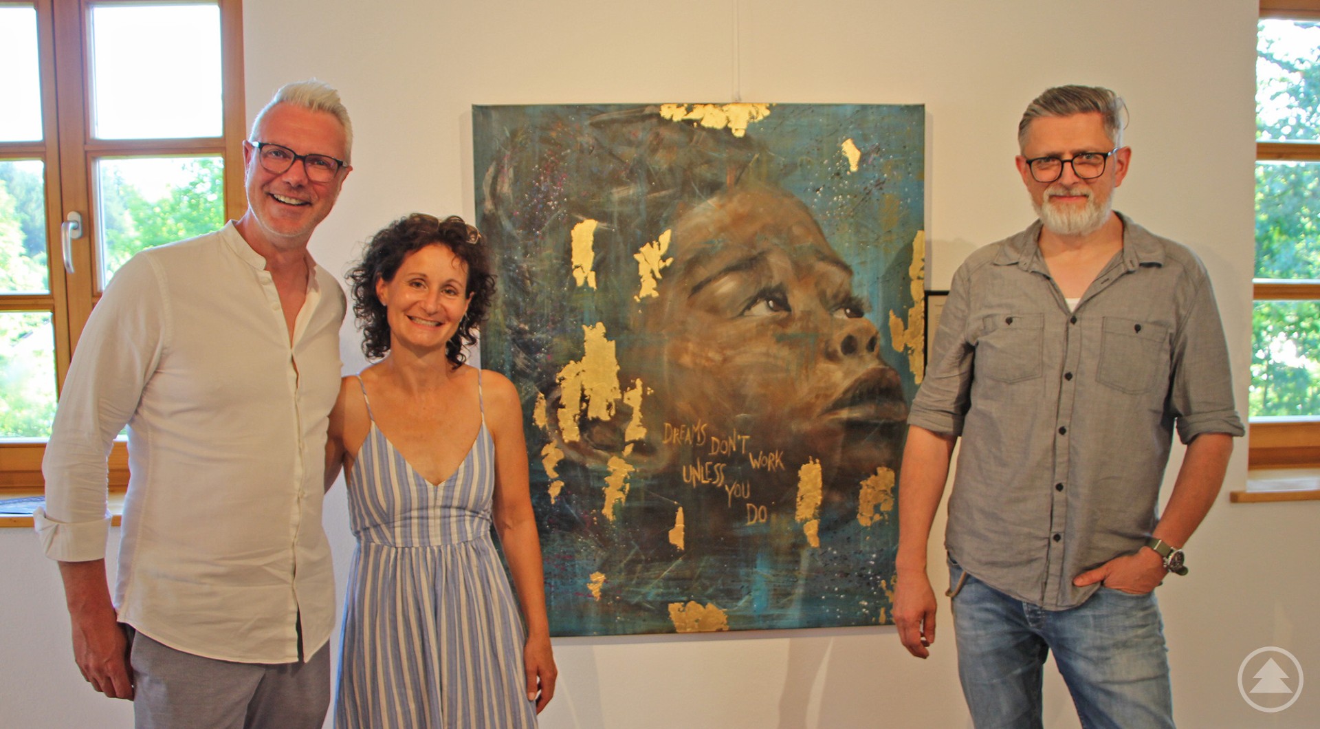 Künstlerin Christiane Binder mit Laudator Mario Götz (links) und Christian Binder von der Nationalparkverwaltung. Drei Personen stehen in einer hellen Ausstellung vor einem großformatigen Porträtgemälde eines Kindes mit goldenen Akzenten. Links ein Mann in weißem Hemd, in der Mitte die Künstlerin im gestreiften Sommerkleid, rechts ein Mann in grauem Hemd mit Brille.