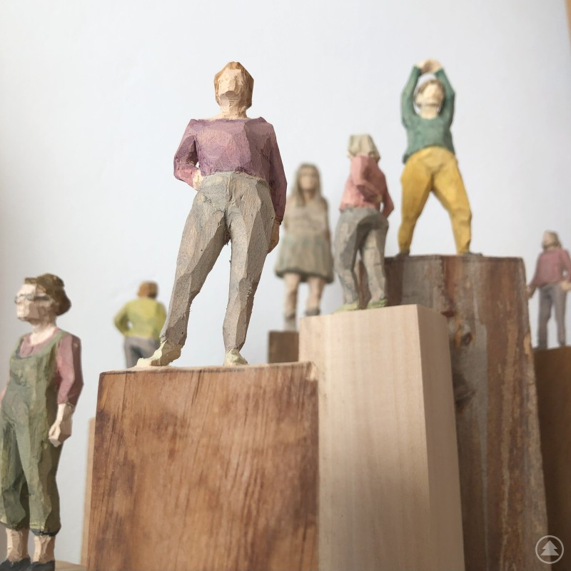 Holzfiguren von Kathrin Ringlstetter: Ausdrucksstark und aus einem Stück gearbeitet. Mehrere farbige Holzskulpturen stehen auf Holzsockeln.