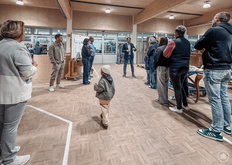 Felix Graf jun. (rechts) von der Firma Dipl.-Ing. Felix Graf GmbH - Werkstätte für Innenausbau in Zenting führt interessierte Besucherinnen und Besucher - unter anderem Wirtschaftsreferent Johannes Gastinger - durch das Familienunternehmen. Eine Gruppe von Besucherinnen und Besuchern steht in einer modernen Werkhalle, während ein Mitarbeiter über die Firma informiert.