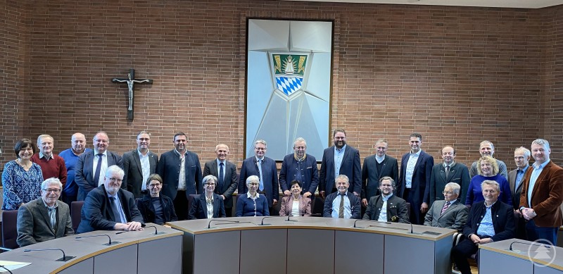 Die zehn Geehrten (vorne sitzend) mit den Ehrengästen, Bürgermeistern, Angehörigen und Vorschlagseinreichern (stehend dahinter). Gruppenfoto im Großen Sitzungssaal des Landratsamtes: Vorne sitzen die zehn Geehrten, dahinter stehen Ehrengäste, Bürgermeister und Angehörige. Im Hintergrund sind eine Kreuzfigur und ein großes Wappen an der Wand zu sehen.