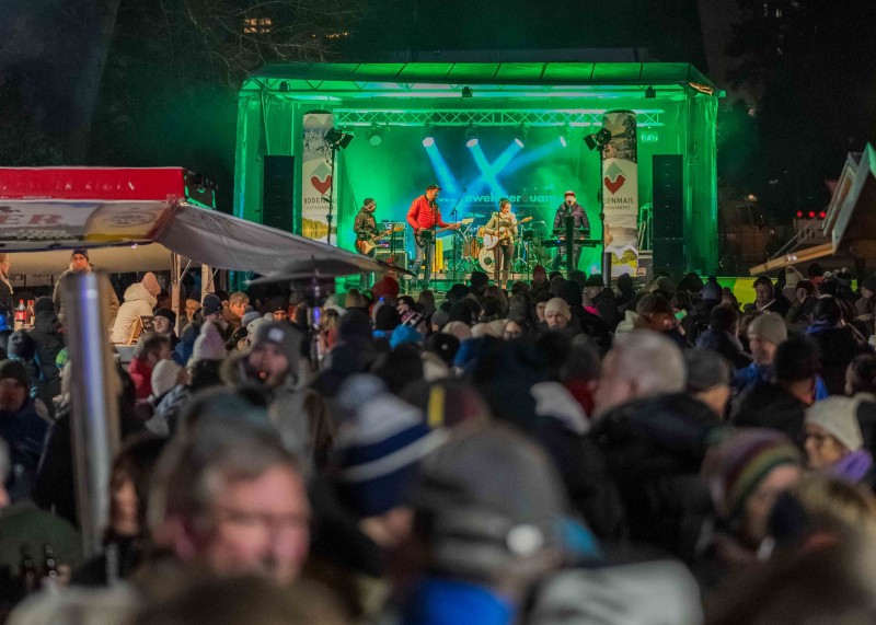 Après-Ski-Party nach dem ArberBlitz mit den Kasplattnrockern Große Winterparty bei Nacht mit vielen Besuchern, Verkaufsständen und Beleuchtung auf dem Veranstaltungsgelände.