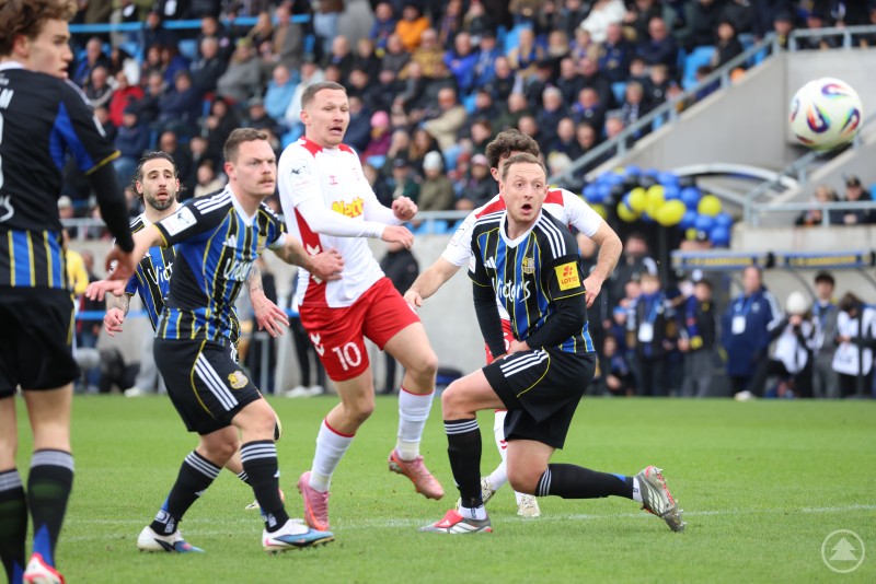 Mehrere Fu&szlig;ballspieler verfolgen aufmerksam den Ball in der Luft w&auml;hrend einer Spielsituation.