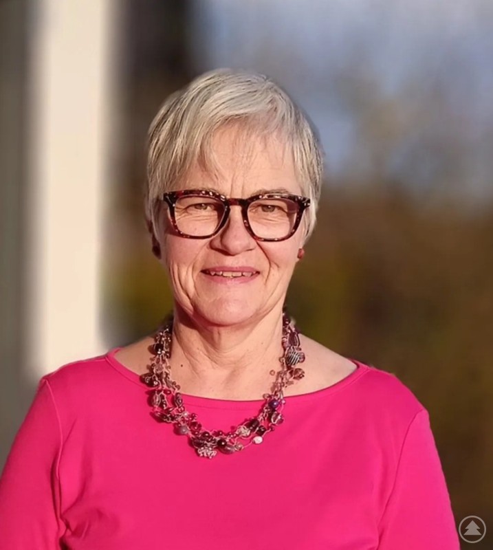 Künstlerin Petra Malarski bringt vielfältige Ausdrucksformen in ihre Werke ein. Petra Malarski lächelt in die Kamera, trägt Brille und pinkes Oberteil.