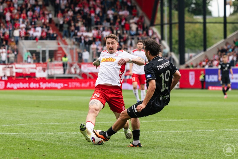 Ein Zweikampf an der Außenlinie: Ein Jahn-Spieler versucht den Ball gegen einen Schweinfurter Abwehrspieler zu behaupten.