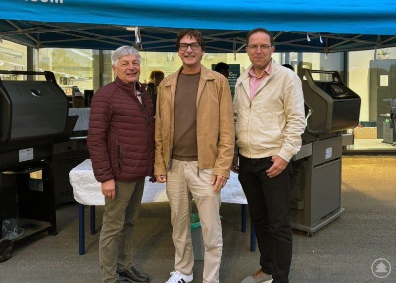 Trafen sich zum Austausch bei der neuen Raiffeisen Ware Bayerischer Wald in Röhrnbach: Bürgermeister Leo Meier (links), sein Perlesreuter Kollege Gerhard Poschinger (rechts) und Regionalmanager Stefan Schuster. Drei Männer stehen unter einem blauen Pavillon mit der Aufschrift „Napoleon“ und lächeln in die Kamera.