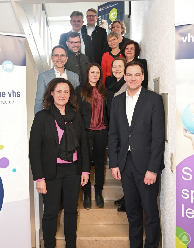 Die Präsidentin des Bayerischen Volkshochschulverbands BVV Dr Ute Eiling Hütig MdL links unterhielt sich unter anderem mit Landrat Sebastian Gruber rechts und vhs Leiterin Dr Karina Fisch vorne Mitte über die Herausforderungen mit denen kleine ländliche Volkshochschulen zu kämpfen haben. Mehrere Vertreter von Volkshochschulen sowie politische Verantwortliche stehen gemeinsam auf einer Treppe im Gebäude der vhs Freyung-Grafenau. Im Vordergrund sind Landrat Sebastian Gruber, vhs-Leiterin Dr. Karina Fisch und die Präsidentin des Bayerischen Volkshochschulverbands Dr. Ute Eiling-Hütig zu sehen.