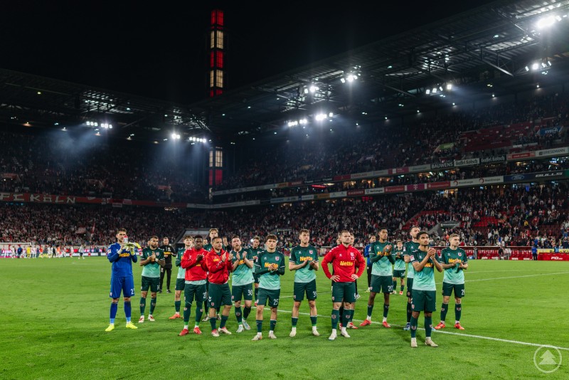 Die Spieler des SSV Jahn bedanken sich nach dem Spiel beim Auswärtspublikum im RheinEnergieSTADION. Mannschaft des SSV Jahn Regensburg steht nach dem 1:1-Spiel im Stadion vor den Fans und applaudiert.