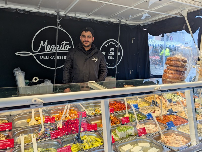 Marktverk&auml;ufer pr&auml;sentiert mediterrane Aufstriche und Spezialit&auml;ten