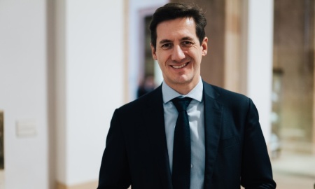 MdL Dr. Stefan Ebner Das Bild zeigt MdL Dr. Stefan Ebner in einem dunklen Anzug mit hellblauem Hemd und dunkelblauer Krawatte. Er lächelt in die Kamera und steht in einem Innenraum, vermutlich in einem öffentlichen oder offiziellen Gebäude.