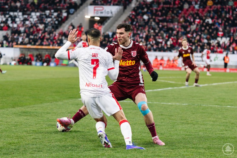 Intensiver Zweikampf zwischen dem SSV Jahn Regensburg und Rot Weiss Essen an der Hafenstraße. Zwei Fußballspieler im Zweikampf um den Ball im Stadion an der Hafenstraße, im Hintergrund dicht besetzte Tribünen.
