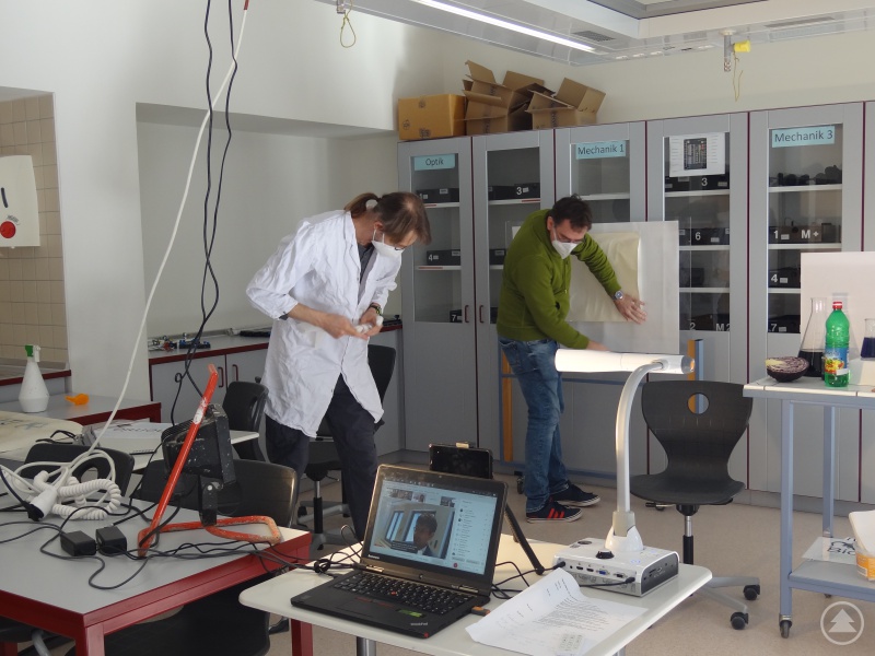 Hinter den Kulissen: Mit Enthusiasmus meistern alle Beteiligten am Tag der offenen Tür 2021 die nicht zu unterschätzenden technischen Herausforderungen einer virtuellen Veranstaltung (hier: Michael Behringer (links) und Matthias Gottschalk (rechts) bzw. Schulleiter Christian Zitzl (Desktop)).