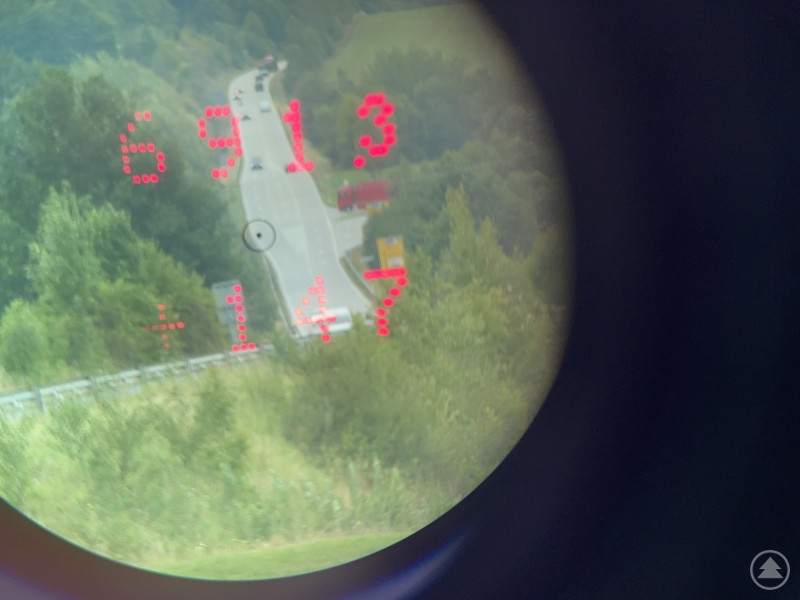 Blick durch ein Lasermessgerät auf eine Bundesstraße, im Display wird eine Geschwindigkeit von 147 km/h angezeigt.