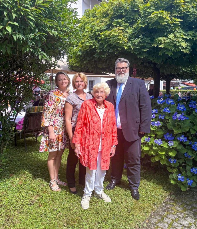 2. Bürgermeister Andreas Rother (v.r.) in bester Feierlaune gemeinsam mit Hildegunde Brummer (ehrenamtliche Verwaltungsrätin), Marina Probst (Betriebsleiterin) und Rinata Deibele (Pflegedienstleitung) Vier Personen – darunter zwei Frauen in Sommerkleidung, eine ältere Dame in Rot und ein Mann im Anzug – stehen lächelnd vor blühenden Hortensien im Garten des Seniorenstifts.