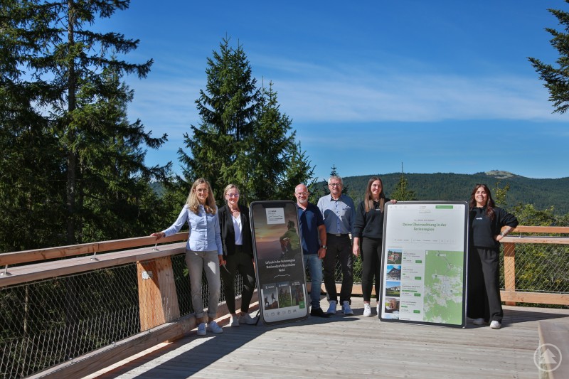 Partner bei der Umsetzung des neuen Portals: Ferienregion Nationalpark und Agentur ready Marketing + Design. Sechs Personen stehen auf dem Baumwipfelpfad, neben ihnen große Display-Attrappen mit der Darstellung des neuen Urlaubsportals.