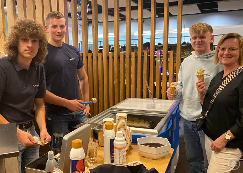 Auszubildende verwöhnen Besucherinnen und Besucher mit Eiscreme. Zwei Auszubildende servieren Eis an Besucherinnen und Besucher während der Veranstaltung.