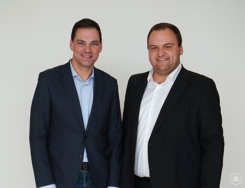 Dank und Glückwunsche an LR Sebastian Gruber von Kreisvorsitzenden Florian Eder Zwei Männer in Anzug und Hemd stehen nebeneinander vor hellem Hintergrund und blicken in die Kamera.