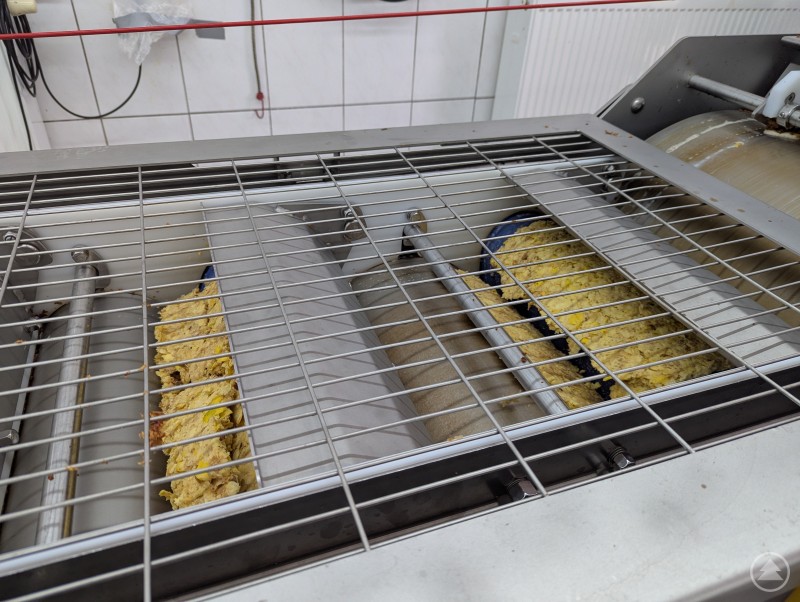 Die Bandpresse befördert das Apfelmus weiter und presst daraus mit 3 bis 3,5 Tonnen Saft. Bandpresse mit weitergeleitetem Mus aus Äpfeln