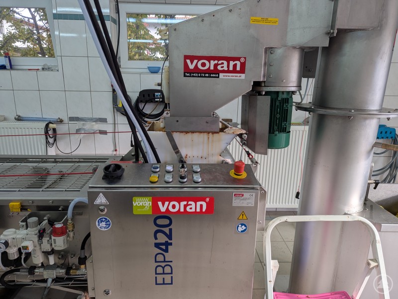 Der Turm mit der Förderschnecke zieht das Obst nach oben und leitet es an die Bandpresse weiter. Turm mit Trichter und Bandpresse für die Saftherstellung