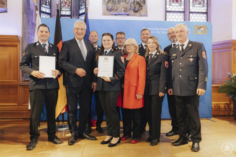 (v. l. n. r.): Uli Hurzlmeier (Thomas-Krenn), Staatsminister Joachim Herrmann, Kreisbrandmeister Martin Bauer, Steffi Graf (Thomas-Krenn), Kreisbrandmeister Harald Gibis, stv. Landrätin Helga Weinberger, Kreisbrandmeister Armin Garhammer, Kreisbrandmeisterin Susanne Bauer, Kreisbrandinspektor Thomas Thurnreiter, Kreisbrandrat Norbert Süß. Vertreterinnen und Vertreter der Thomas-Krenn.AG sowie eine Delegation aus dem Landkreis Freyung-Grafenau stehen gemeinsam mit Staatsminister Joachim Herrmann und Feuerwehrführungskräften auf der Bühne.
