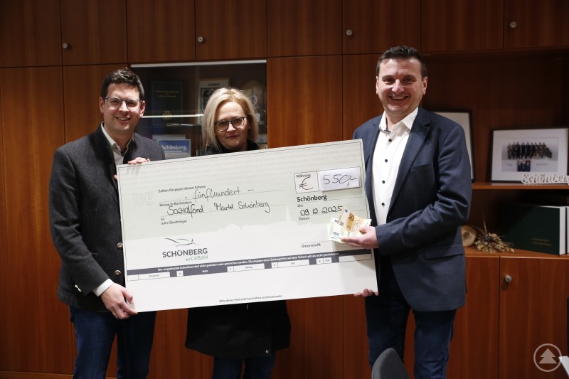 Bürgermeister Martin Pichler (v.l.) und Carolin Garhammer freuen sich über Extra-Hilfe von TSV und 1. Vorsitzender Christian Brunnbauer. Drei Personen stehen in einem Büro vor einer Holzschrankwand und halten gemeinsam einen symbolischen Scheck über 550 Euro. In der Mitte steht eine Frau, links und rechts jeweils ein Mann, alle lächeln in die Kamera.