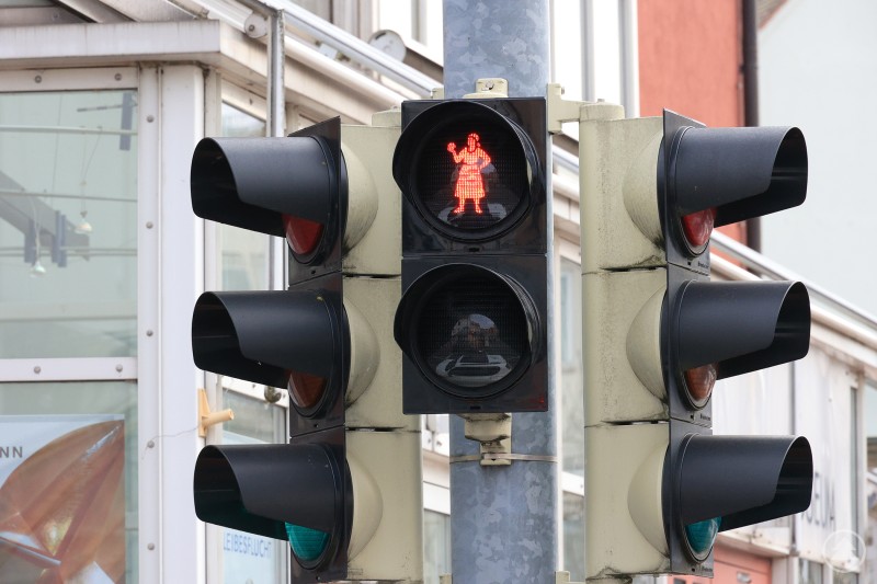 Die neue Fußgängerampel im Östlichen Stadtgraben zeigt als rotes Signal die Knödelwerferin. Nahaufnahme einer Fußgängerampel im Stadtgebiet. Das rote Ampelmännchen zeigt das Motiv einer stilisierten Frau, die einen Knödel wirft – die sogenannte Knödelwerferin.