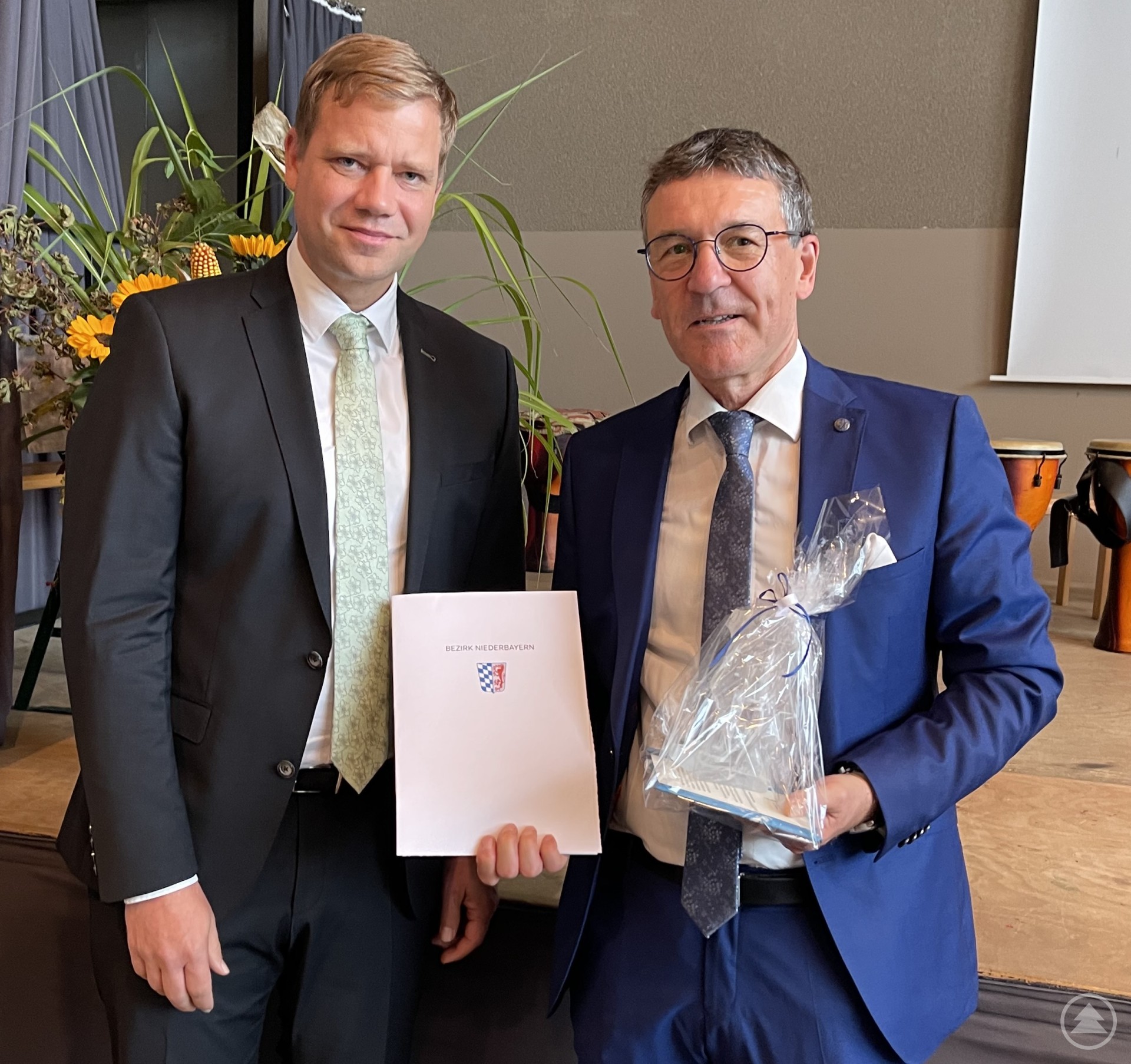 Bezirkstagspräsident Dr. Olaf Heinrich (l.) überreicht Fritz Geisperger seine Urkunde und den Panther des Bezirks Niederbayern für seine langen Dienste