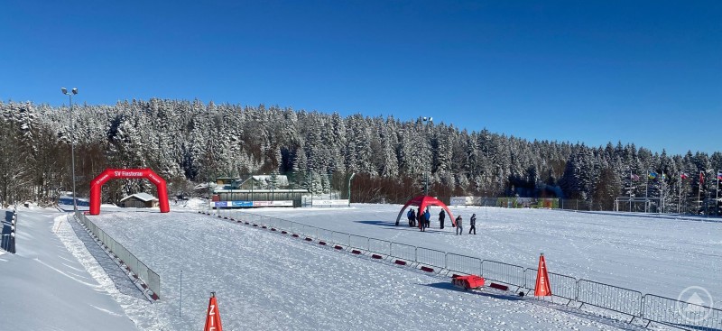 Es kann losgehen: Der Start und das Ziel sowie die Zuschauerbereiche im Finsterauer Skistadion sich aufgebaut und die Rennstrecken präpariert für den Langlauf-Weltcup für Menschen mit Handicap. Blick auf das Finsterauer Skistadion mit aufgebauten Zuschauerbereichen und präparierter Loipe bei winterlicher Landschaft.