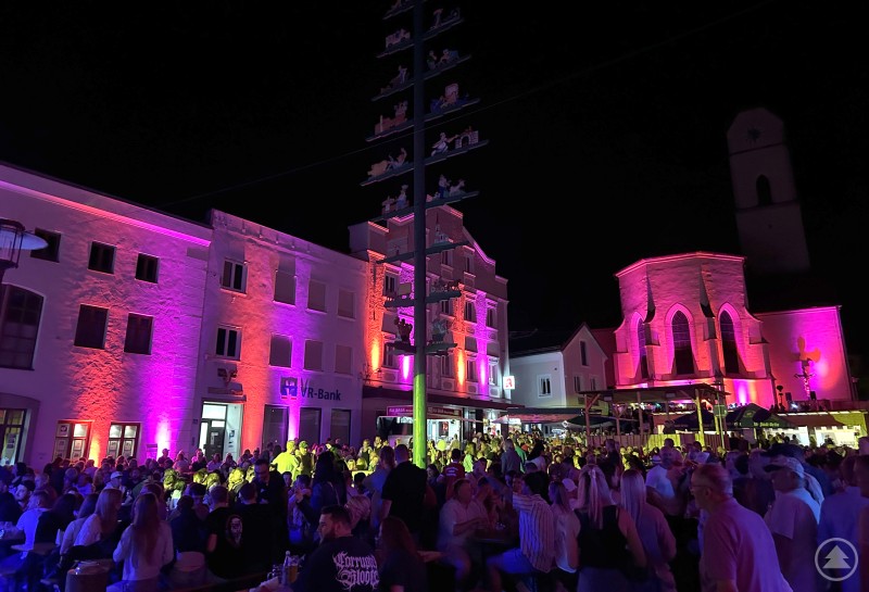 Marktbeleuchtung bedeutete an den zwei Marktfesttagen, dass sich die Marktsilhouette zur bunten Arena mit Sternenhimmel wandelte. Nächtliche Stimmung auf dem belebten Marktplatz, farbenfroh beleuchtete Gebäude und dicht gedrängte Besucher.