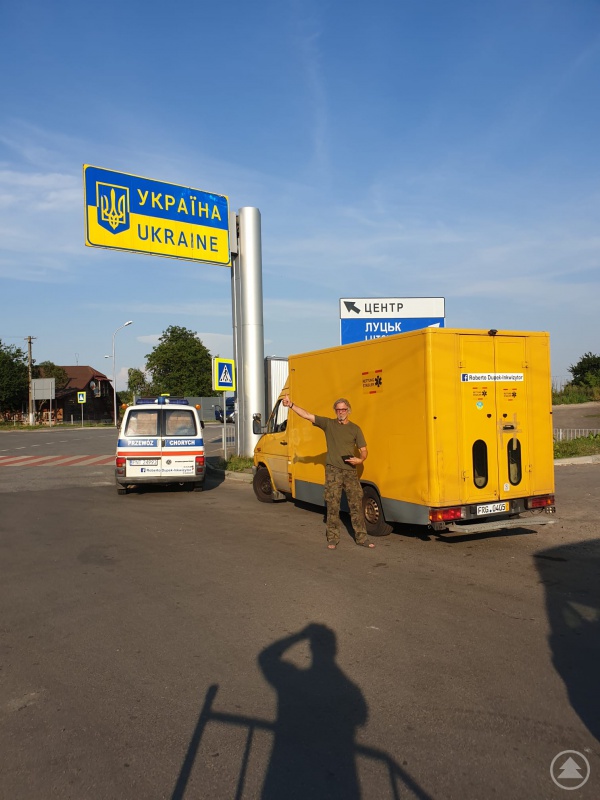 An der Grenze zur Ukraine mit dem gelben Transporter unter dem blauen Himmel.