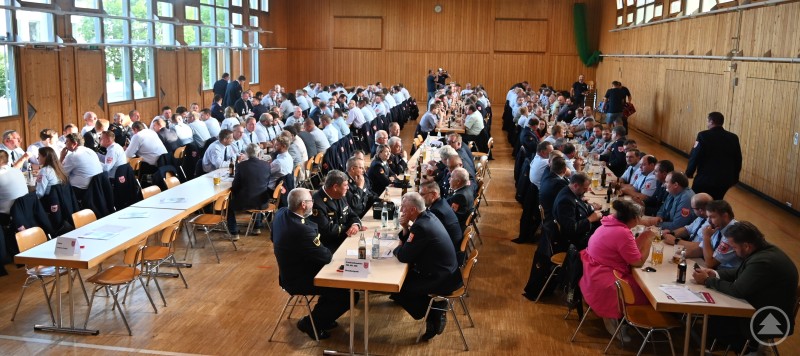 87 Kommandanten der Kreisfeuerwehren hatten am Dienstagabend im Rahmen einer außerordentlichen Dienstversammlung in der Josef-Eder-Halle in Röhrnbach ihre Stimmen abgegeben. Rund hundert Feuerwehrkommandanten und Gäste sitzen in Uniform an langen Tischen in einer Turnhalle während der Dienstversammlung in Röhrnbach.