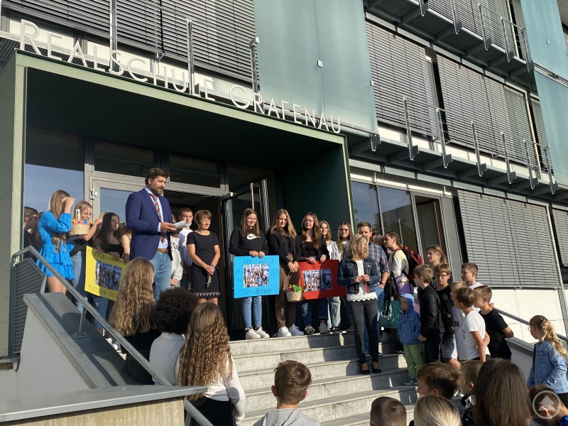 Realschuldirektor Ferdinand Klingelhöfer begrüßt die neuen Realschüler zusammen mit den Tutoren und Klassenleitern am Schuleingang.