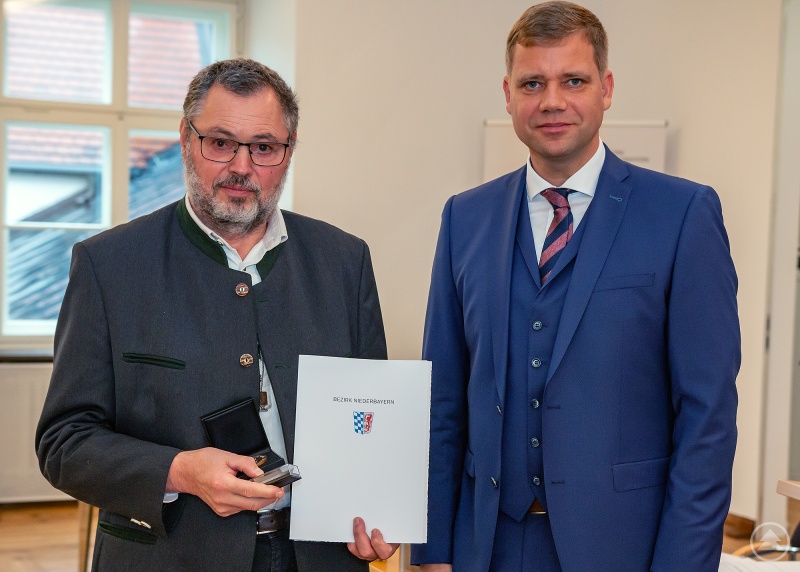 Bezirkstagspräsident Dr. Olaf Heinrich überreicht dem ehemaligen Bezirksrat Anton Maller die Bronzene Bezirksmedaille.