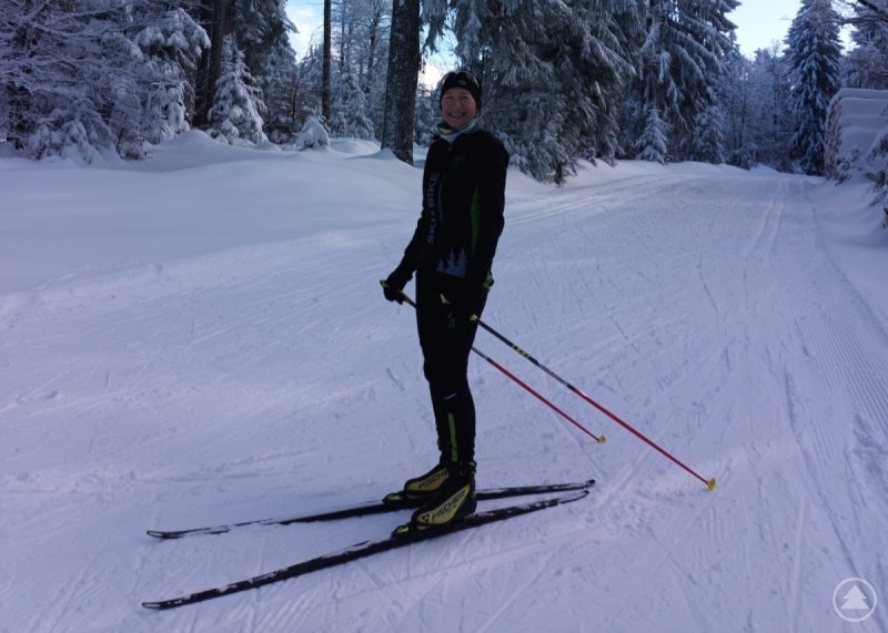 Jeanette Loibl, Mitarbeiterin der Tourist Information ist auch in ihrer Freizeit wintersportbegeistert Eine Person steht auf einer frisch gespurten Langlaufloipe im winterlichen Wald auf der Rusel; ringsum schneebedeckte Bäume, darüber ein teils blauer Himmel.
