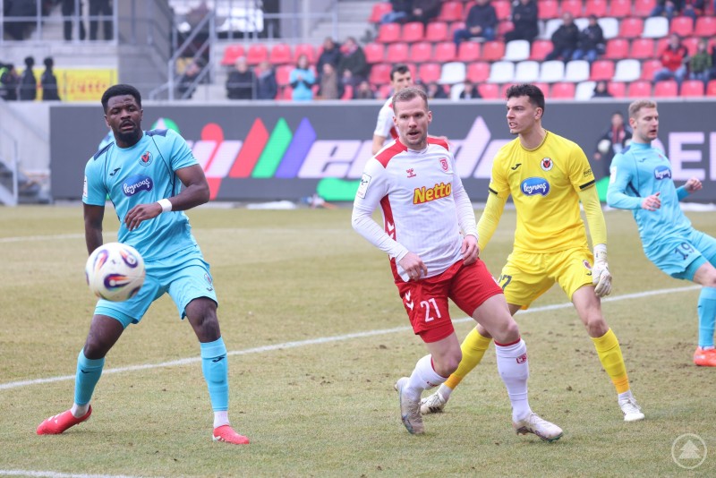 Der SSV Jahn Regensburg suchte immer wieder den Weg nach vorne, wurde jedoch von der Kölner Defensive konsequent gestört. Ein Spieler von Viktoria Köln klärt den Ball im eigenen Strafraum, während ein Angreifer des SSV Jahn Regensburg aufmerksam auf eine mögliche Abpraller-Situation wartet. Der Torhüter der Gäste steht bereit.