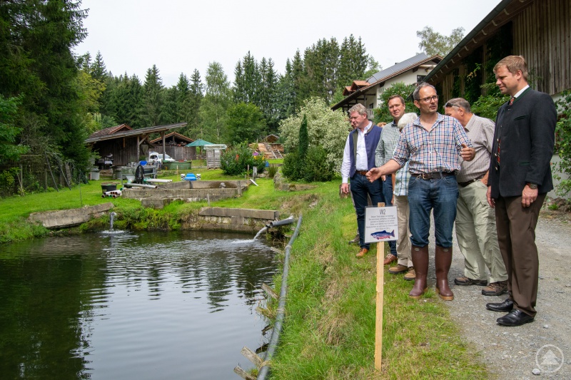 Thomas Flohr führte Bezirkstagspräsident Dr. Olaf Heinrich (re.) sowie die Bezirksräte Franz Schreyer und Josef Heisl (v.li.) durch seinen Fischzuchtbetrieb in Grünmühl.