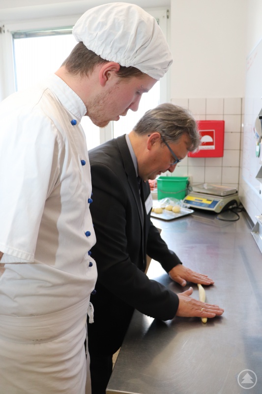 Der Bischöfliche Beauftragte für die Caritas, Diakon Konrad Niederländer, formt assistiert von Florian Kempinger Bre’zn.