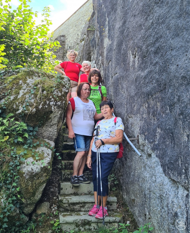 Rita Hagl-Kehl (oben) und Brigitte Grantner (Mitte) mit einem Teil der Wandergruppe am Rand der Burganlage Ranfels.