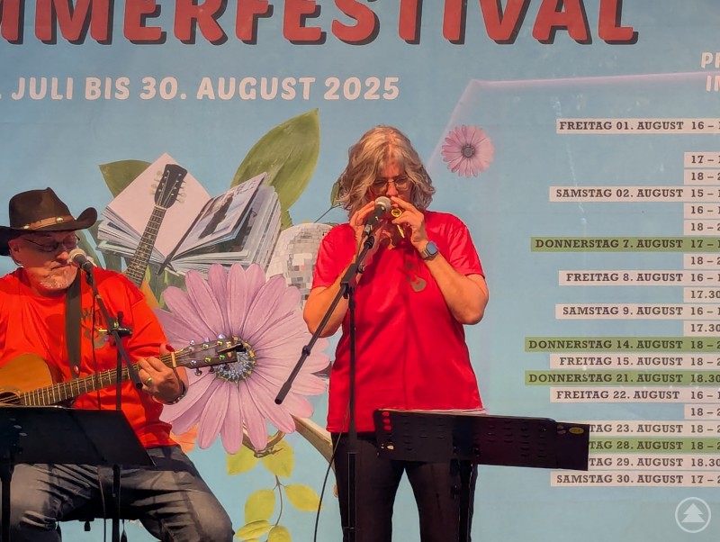 Musikerin spielt Kazoo auf der Freiluftbühne