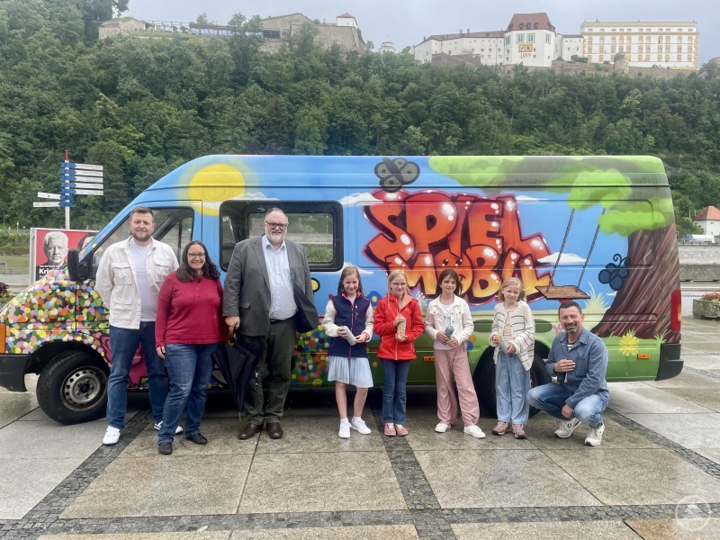Oberbürgermeister Jürgen Dupper (3. v. l.) bedankt sich über den neuen Anstrich des Spielmobils beim Stadtjugendpfleger Edmund Kriegl (rechts), bei der Geschäftsführerin des Stadjugendrings Passau Karin Meyer (2. v. l.), beim Graffitikünstler Fabian Edenharder und bei den Siegerinnen des Gestaltungswettbewerbes.