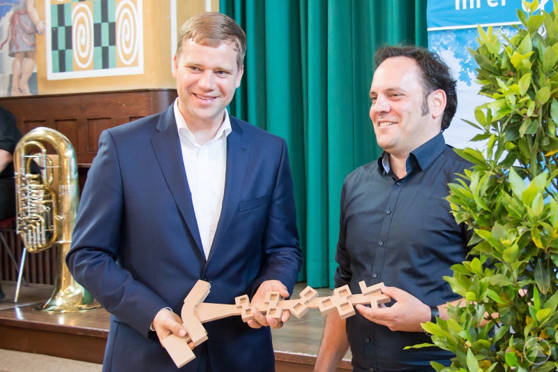 Architekt Jochen Eggert übergibt Bezirkstagspräsident Dr. Olaf Heinrich den symbolischen Schlüssel.