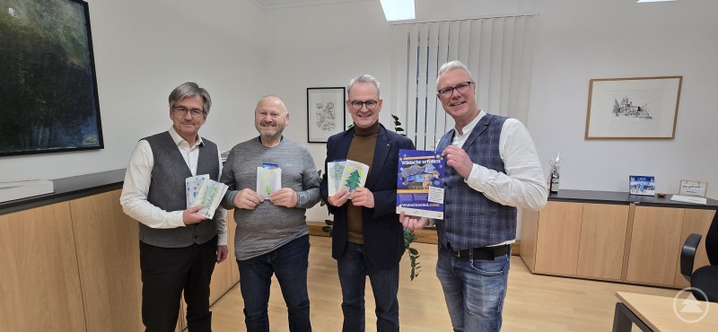 Ein schönes Zeichen der internationalen Solidarität. Kinder aus Thyrnau, Kellberg und Straßkirchen gestalten Weihnachts-Tüten für die Straßen-Kinder in Satu Mare. (V.li.) Die Caritasvorsitzenden Thomas Weggartner (Salzweg/Straßkirchen) und Hans Gottinger (Thyrnau) mit Caritasvorstand Stefan Seiderer und Mario Götz, dem Koordinator der Auslandshilfe. Vier Männer stehen nebeneinander in einem Besprechungsraum und halten Informationsmaterial sowie Spendenunterlagen in den Händen. Sie lächeln in die Kamera und präsentieren gemeinsam ein Projekt der internationalen Caritas-Hilfe.