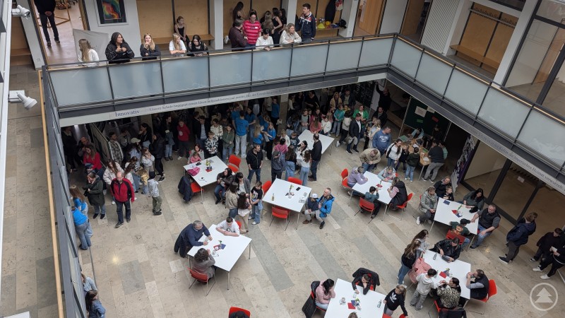 Ein volles und buntes Schulhaus präsentierte sich am Tag der offenen Tür an der Realschule Grafenau. Blick von oben in die Aula der Realschule Grafenau mit vielen Besuchern an Tischen und auf den Gängen.