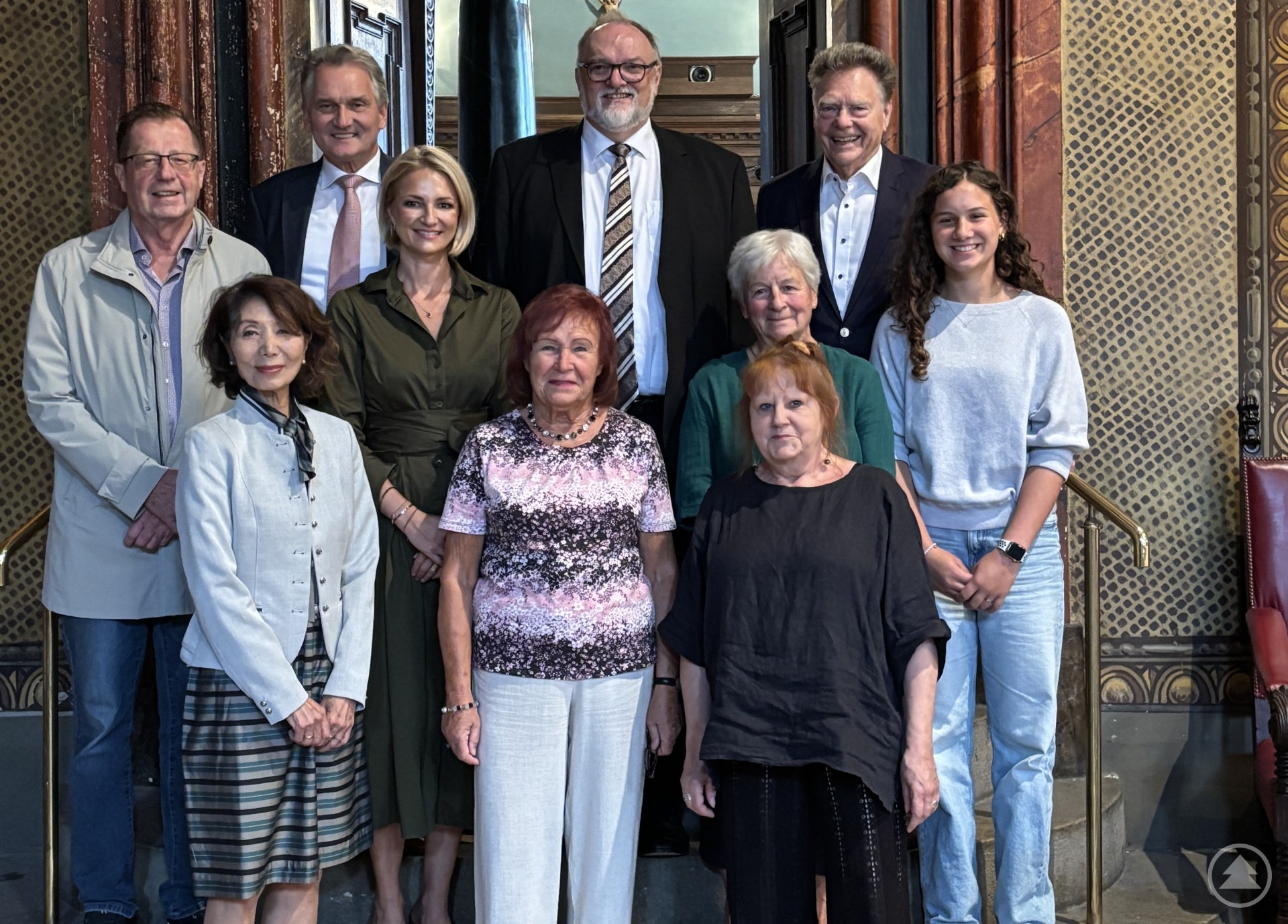 Die Geehrten mit Oberbürgermeister Jürgen Dupper beim Festakt im Kleinen Rathaussaal der Stadt Passau. Eine Gruppe von elf Personen steht auf einer Treppe im prunkvoll gestalteten Kleinen Rathaussaal in Passau. In der Mitte hinten steht Oberbürgermeister Jürgen Dupper. Die Gruppe besteht aus geehrten Bürgerinnen und Bürgern sowie Begleitpersonen.