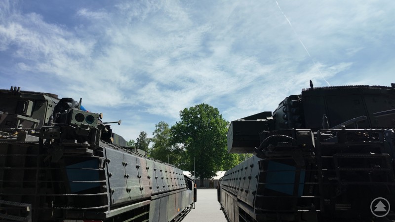 Zwei Schützenpanzer Puma stehen nebeneinander auf einem befestigten Platz. Die Perspektive von hinten betont die wuchtige Panzerung und die Technik auf dem Dach.