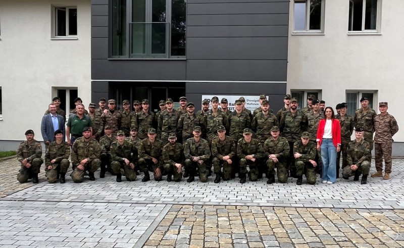 Rund 40 neu versetzte Soldatinnen und Soldaten wurden bei einem Empfang von Stadt und Landkreis Freyung-Grafenau in ihrer „Heimat auf Zeit“ willkommen geheißen. Gruppe von Soldatinnen und Soldaten der Bundeswehr posiert in Uniform vor einem modernen Gebäude, begleitet von zivilen Vertretern.