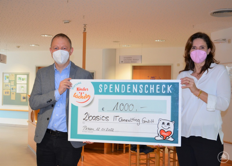 (v.l.) Thomas Höppler, Geschäftsführer der 2basics GmbH in Waldkirchen, spendet 1.000 Euro an die Stiftung Kinderlächeln und übergibt den Spendenscheck hier an Dr. Maria Diekmann, Stiftungsratsvorsitzende der Stiftung Kinderlächeln.