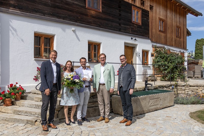 Bezirkstagspräsident Dr. Olaf Heinrich (l.) besuchte nach der Preisverleihung gemeinsam mit Bezirkstagsvizepräsident Dr. Thomas Pröckl (2. v. r.) und Bezirksheimatpfleger Dr. Clemens Knobling (r.) das instandgesetzte Gebäude in Reisach von Diana und Thomas Mittermeier.